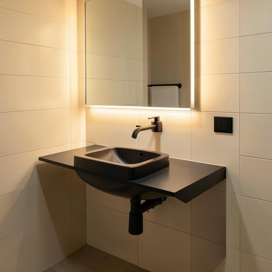 Zona de lavado con acabados minimalistas e iluminación cálida
